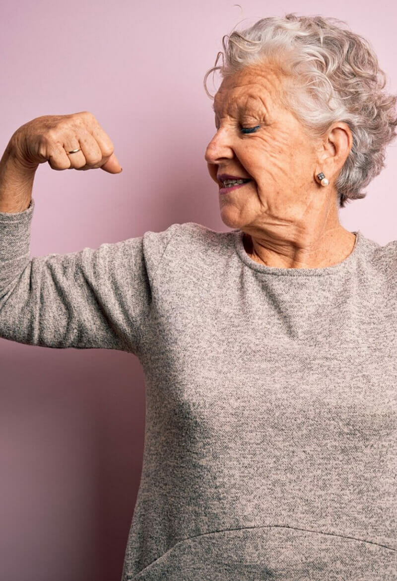 Healthy-Aging Elderly woman flexes her arm