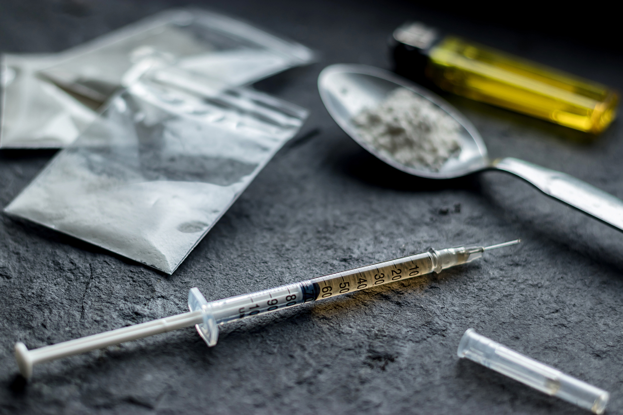 drug syringe and cooked heroin on spoon. drug addiction