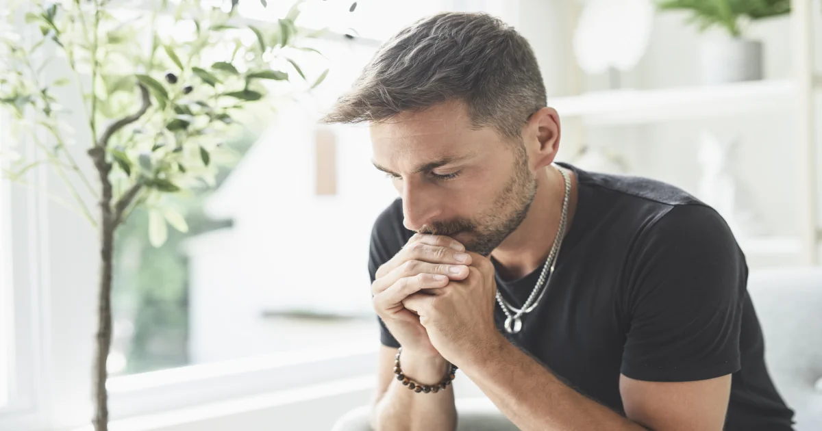 Man sitting alone in quiet reflection, considering the signs and impact of xylazine use and addiction.