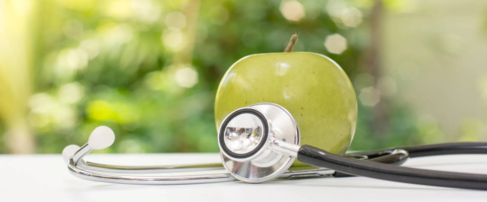 Green apple with stethoscope symbolizing Integrated Primary care for Addiction Treatment at Solstice Health & Wellness Sarasota, FL